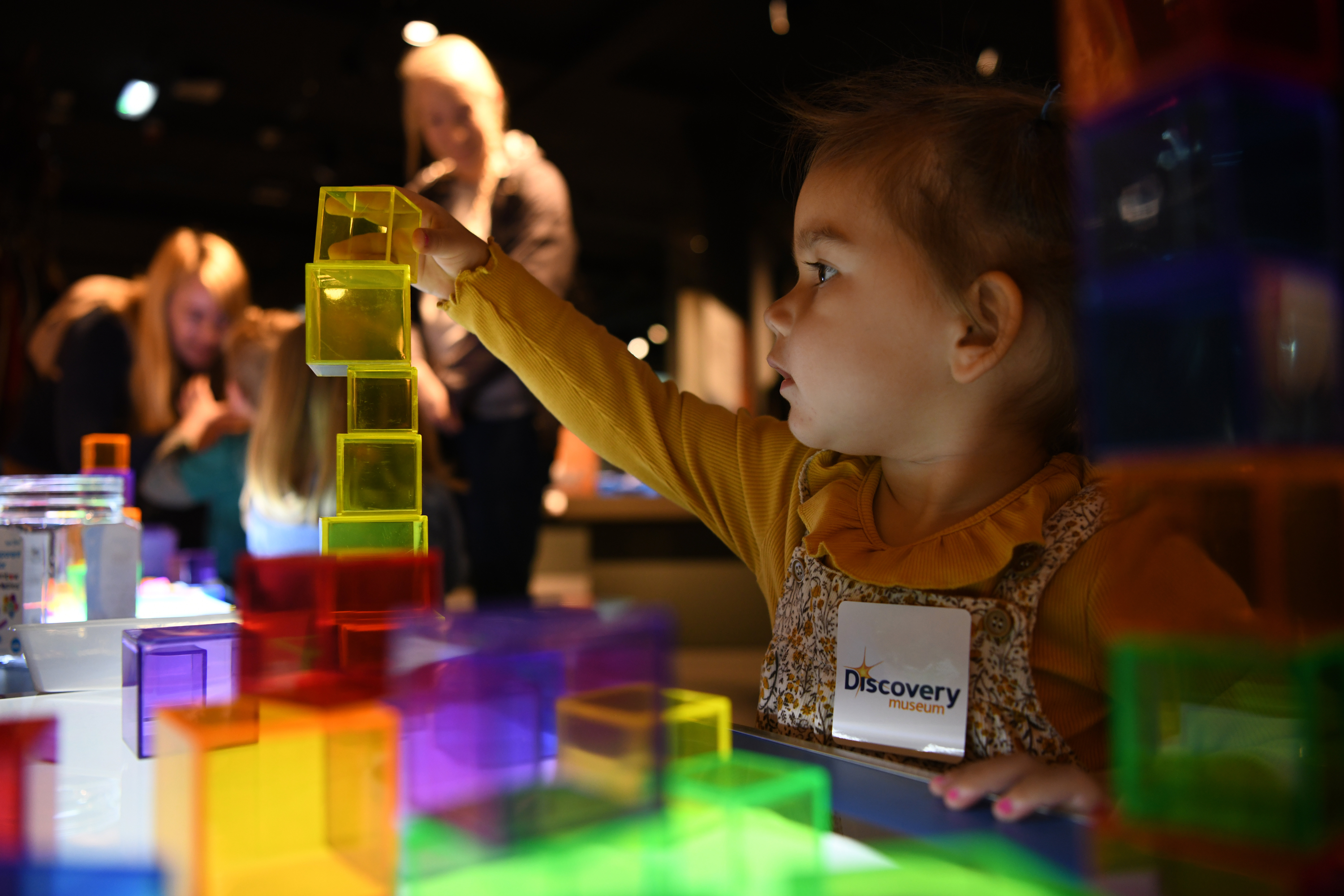 A young child plays with multi-coloured blocks in the museum. A young child plays with multi-coloured blocks in the museum.