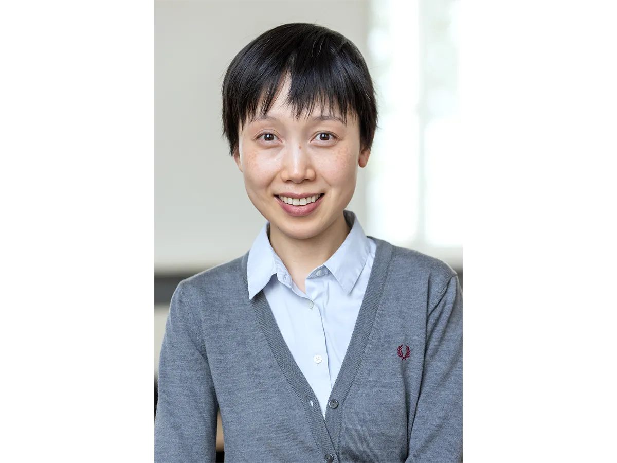 Dr Chun Ann Huang wearig pale blue shirt and grey sweater smiling at camera