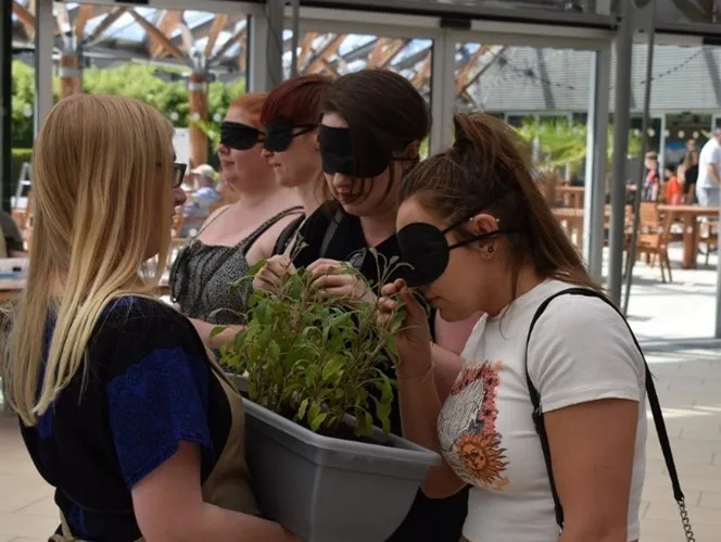 Blindfolded women line up to guess a plant by smell at a sensory laboratory