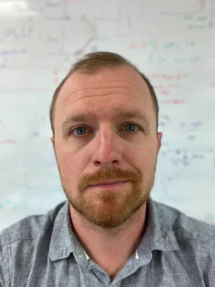 Dr Jon Major with a beard and mustache smiling for camera