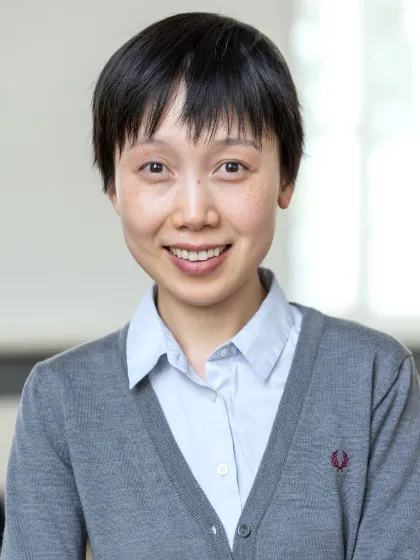 Dr Chun Ann Huang wearig pale blue shirt and grey sweater smiling at camera